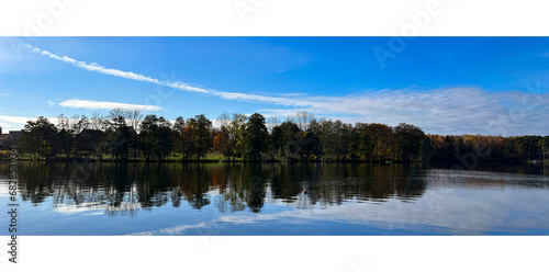 Beautiful evening landscape. Clouds. Reflection of trees in water.