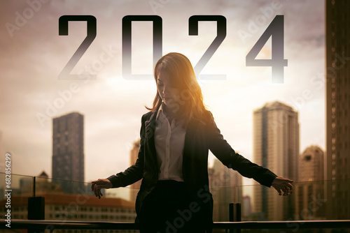 silhouette of successful business woman in sunrise with city background with text 2024 , new year concept photo
