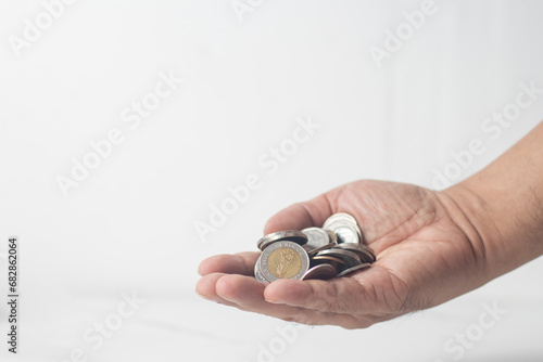The man picked up the coins and arranged them in a stack, reflecting his idea of saving money.