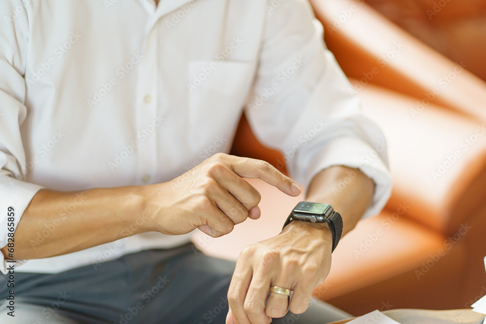 Obraz premium Business man Looking at&nbsp;smart watch In Office online connect Gadget technology