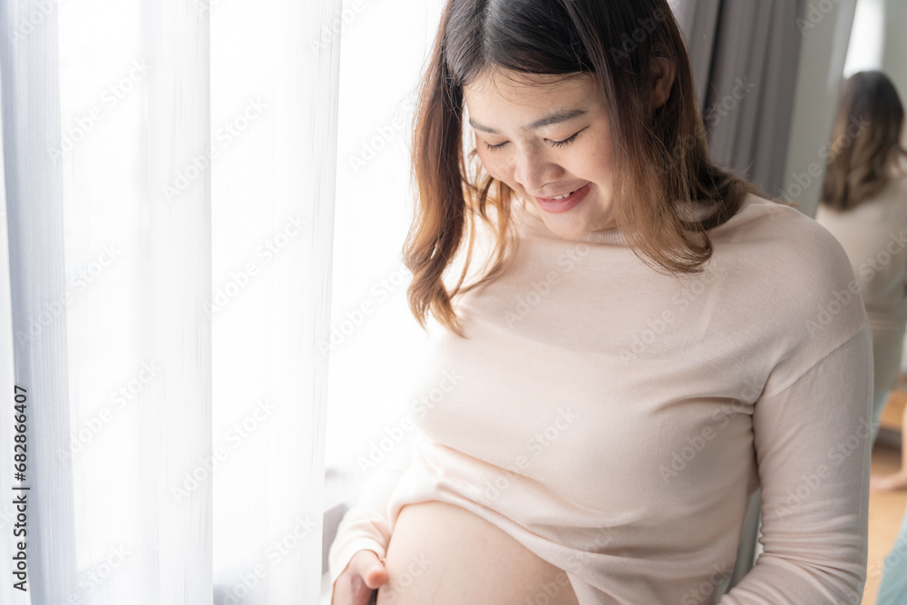 Pregnant asian woman holds hands on belly touching her baby caring about her health Beautiful happy pregnant woman tender mood photo of pregnancy Pregnant asian woman holds hands on belly touching her baby caring about her health Beautiful happy pregnant woman tender mood photo of pregnancy