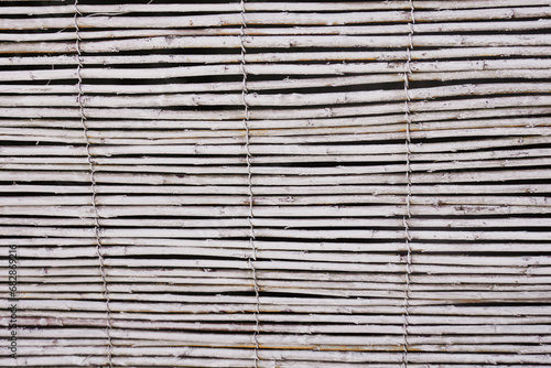 Texture of thin wooden curtain poles. Beach background. 