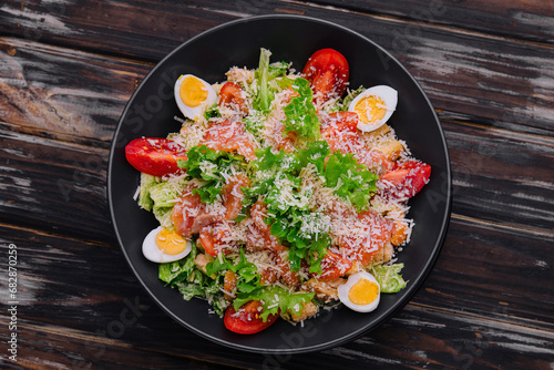 Salad with salmon, lettuce, boiled eggs, cherry tomatoes and parmesan cheese