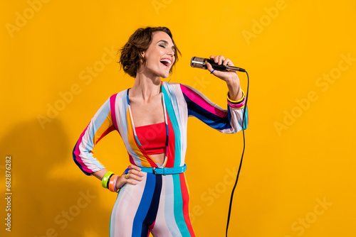 Photo of crazy freak girl wearing old style nostalgia striped costume singing microphone karaoke vocal isolated on yellow color background photo