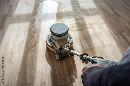 Polishing wooden parquet floor with special orbital machine photo