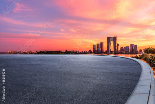 Asphalt road square and city skyline with modern buildings at sunset in Suzhou  Jiangsu Province  China.