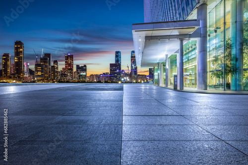 Empty square floors and skyline with modern buildings at night