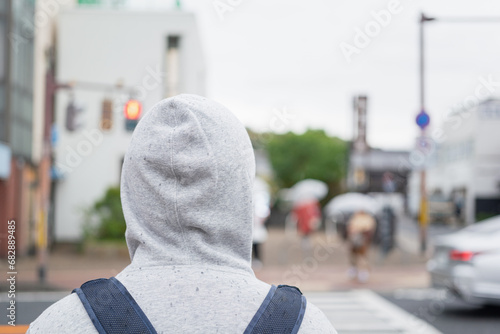 Photo from back of a traveller is sweater of overcoat is waiting for crossing the road. photo