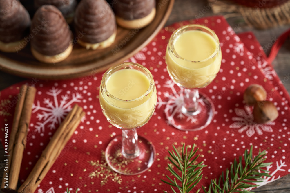 Two glasses of eggnog with wasp nests - no-bake Christmas cookies in the background
