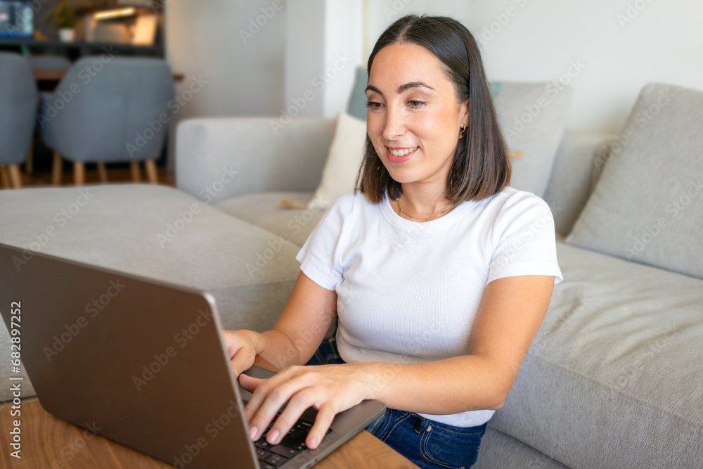 young beautiful smiling woman prints on the laptop - indoors young beautiful smiling woman prints on the laptop - indoors