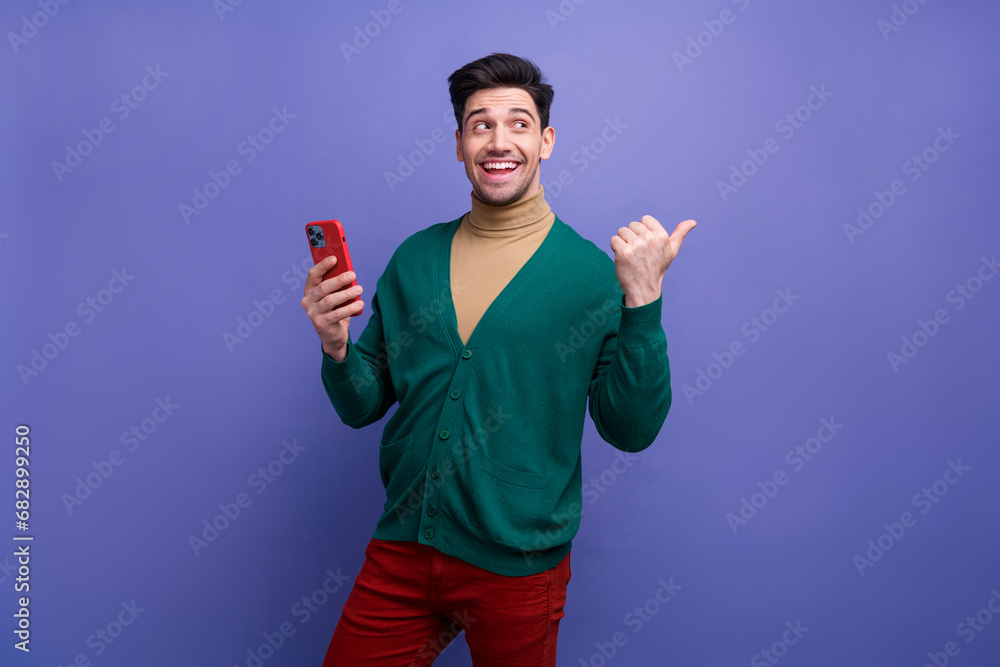 Photo of glamour attractive cheerful man wear trendy clothes recommend modern device shop isolated on purple color background