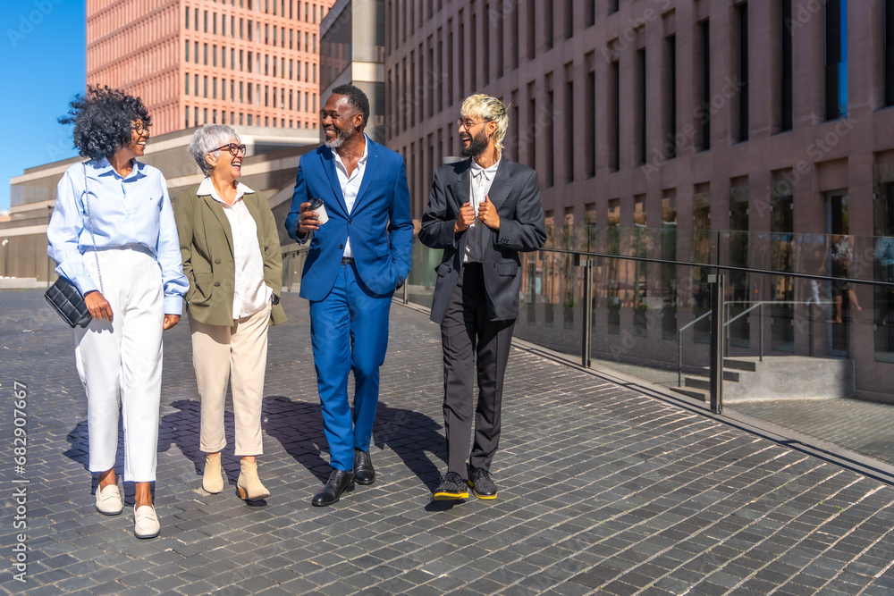 Fototapeta premium Multi-ethnic business people walking relaxed during a coffee break outdoors