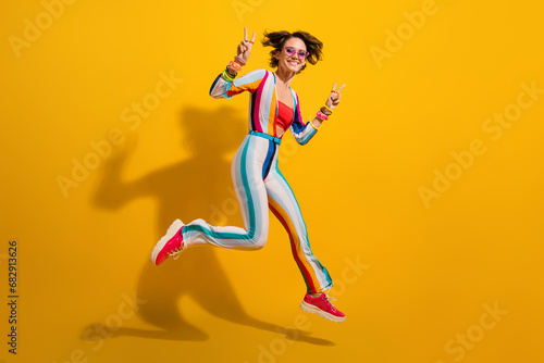 Photo of youth lady jumping enjoy night club fun make v sign isolated shine color background