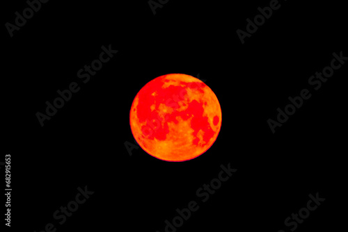 Bright orange red light nature moon object in the night sky, close-up