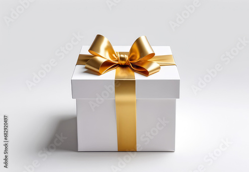 White gift box with golden ribbon bow on light background for design with empty space. Holiday present,Happy Birthday greeting card concept. © svf74