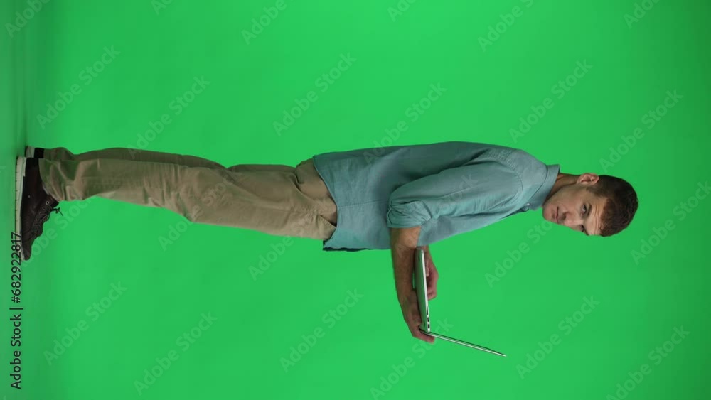 full-length man using a laptop on a green background full-length man using a laptop on a green background