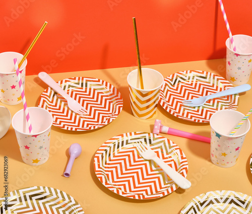 Festive table setting for a holiday party. Colorful plates, forks and cups.