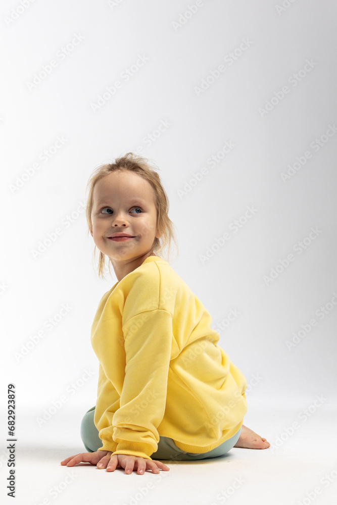Portrait of beautiful cute little toddler girl. Child with funny face in yellow sweatshirt. Pretty smile kid in studio on white background. High quality photo Portrait of beautiful cute little toddler girl. Child with funny face in yellow sweatshirt. Pretty smile kid in studio on white background. High quality photo