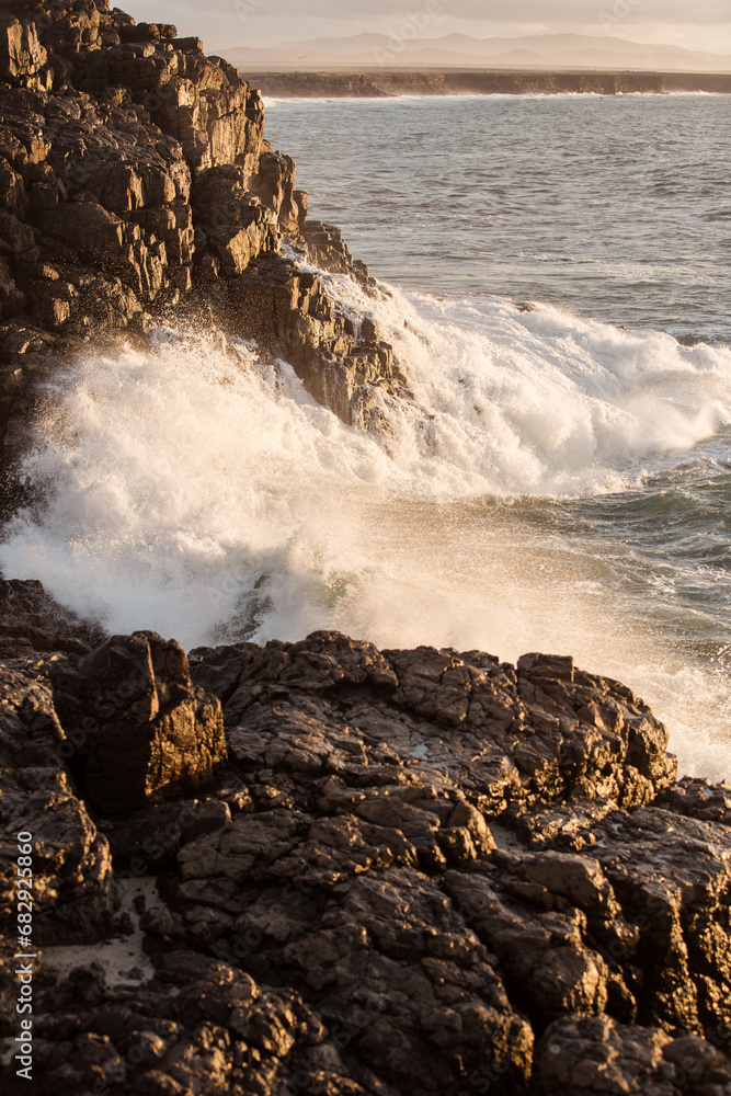Stunning images of waves crushing into the ancient volcanic stones on shore at sunset in Fuerteventura island Spain Stunning images of waves crushing into the ancient volcanic stones on shore at sunset in Fuerteventura island Spain