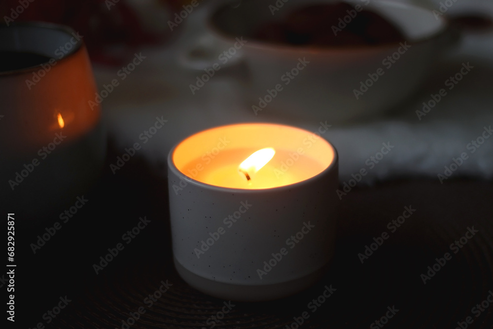 Cup of tea or coffee, glass of wine or juice, bowl of cookies, organic pomegranate, fluffy blanket, pine cones, various Christmas decorations and lit candles on the table. Christmas hygge concept. Cup of tea or coffee, glass of wine or juice, bowl of cookies, organic pomegranate, fluffy blanket, pine cones, various Christmas decorations and lit candles on the table. Christmas hygge concept.
