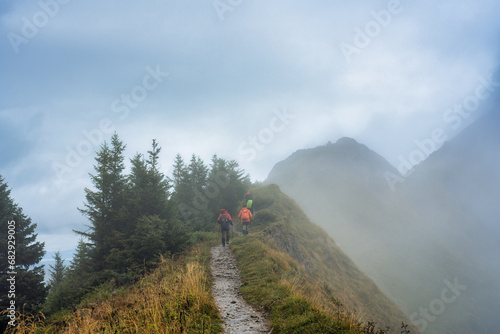 Group of backpacker walking on trail in foggy mountain on the morning at Switzerland