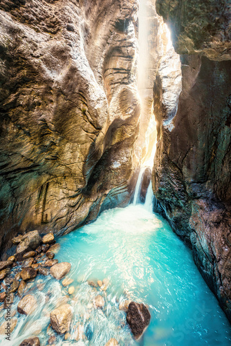 Fototapeta Naklejka Na Ścianę i Meble -  Waterfall with light shines in Rosenlaui glacier gorge at Bernese Alps, Switzerland