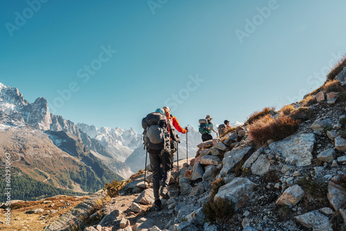 Group of hiker hiking with difficult on mountain trail amidst French alps on sunny day at France