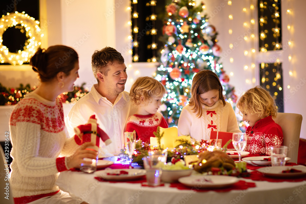 Family with kids having Christmas dinner at tree Family with kids having Christmas dinner at tree