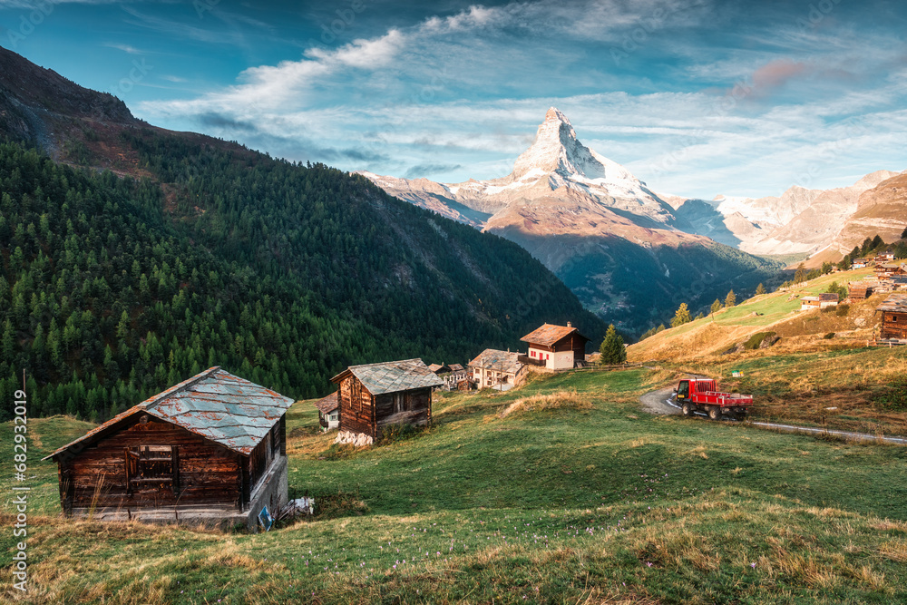 Matterhorn mountain with truck driving on the road and wooden huts on the hill in the morning on autumn at Zermatt, Switzerland