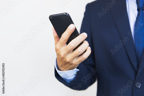 スマホを見るビジネスマン Businessman looking at smartphone