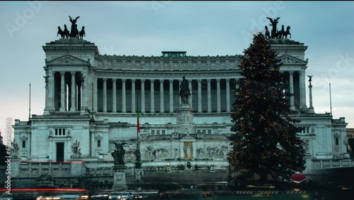 Piazza Venezia in Rome at Christmas time, with the illuminated Christmas tree. Traffic in the capital of Italy with passing cars and lights. Altar of the Fatherland monument from the 20th century photo