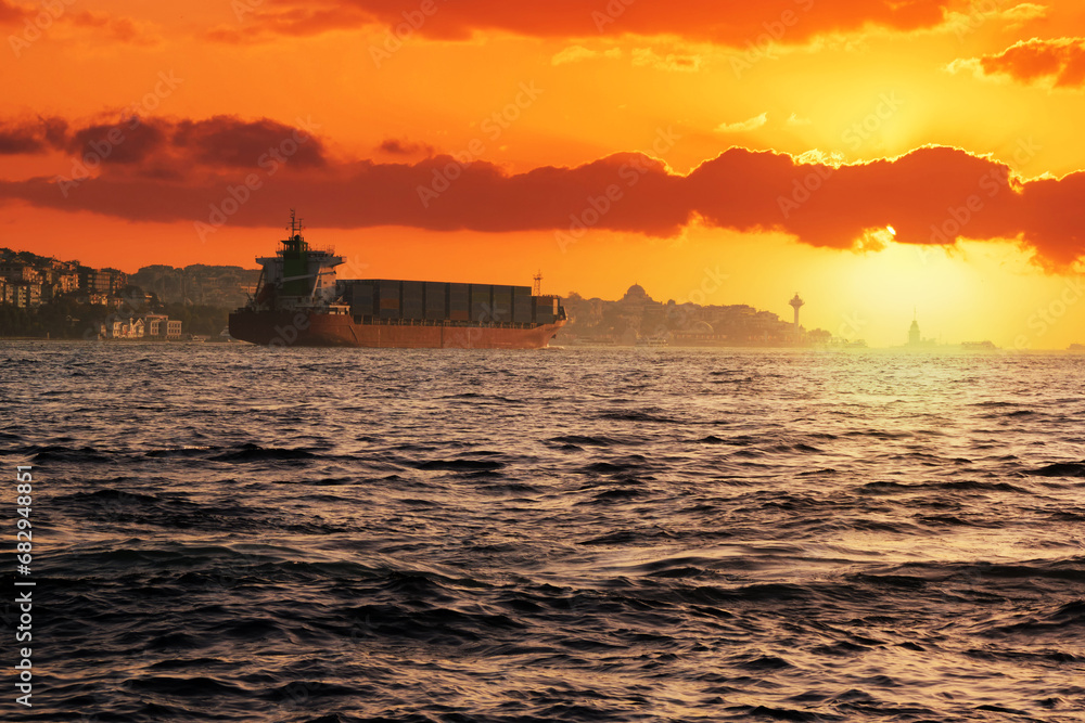 Fototapeta premium A large transport ship with containers on the deck floats on the sea.