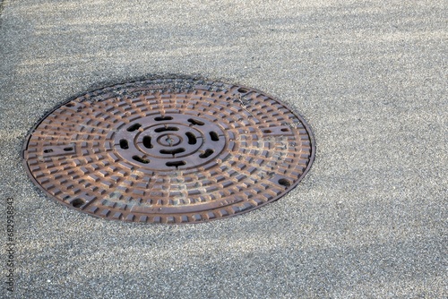 old rusty manhole cover in the street