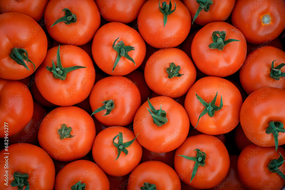 Closeup background photo of fresh ripe tomatoes ready for sale. Top view of juicy red tomatoes. Closeup background photo of fresh ripe tomatoes ready for sale. Top view of juicy red tomatoes.