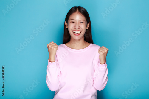 Portrait of a friendly young woman smiling happily, Portrait of a beautiful young woman in a light blue background, One woman acted beautifully cheerful.