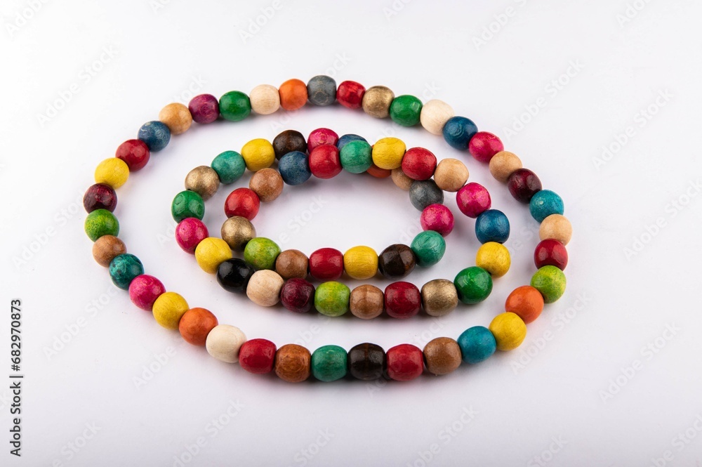 Multicolored wooden beads on a white background. Multicolored wooden beads on a white background.
