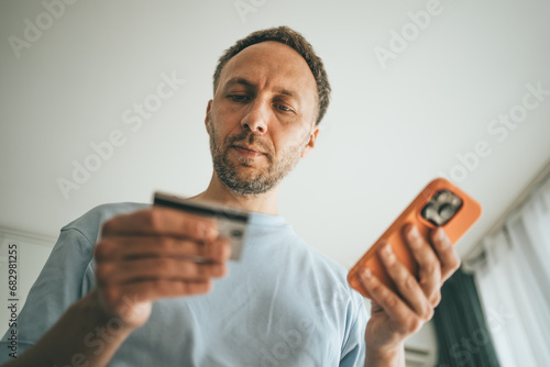 Man enters card details into his phone to make online purchase.