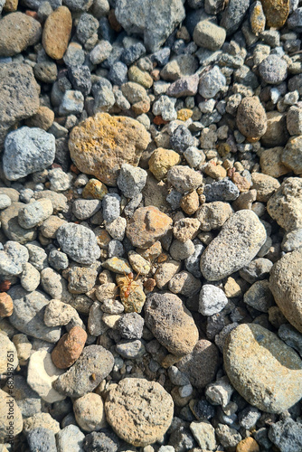 A pile of rocks sitting on top of each other. The rocks are of various sizes and shapes, and they are arranged in a haphazard manner. There is a small ant crawling on one of the rocks