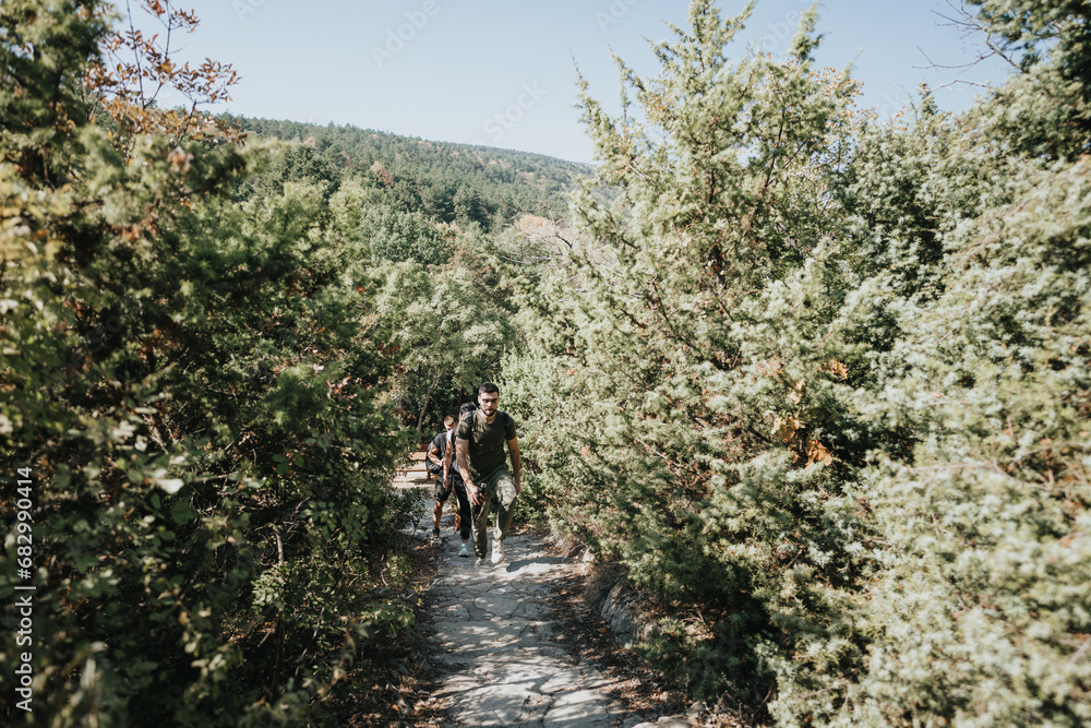 Friends hike through a forest, enjoying a sunny day in nature. They embrace an active lifestyle, exploring the mountainous landscape together. Friends hike through a forest, enjoying a sunny day in nature. They embrace an active lifestyle, exploring the mountainous landscape together.