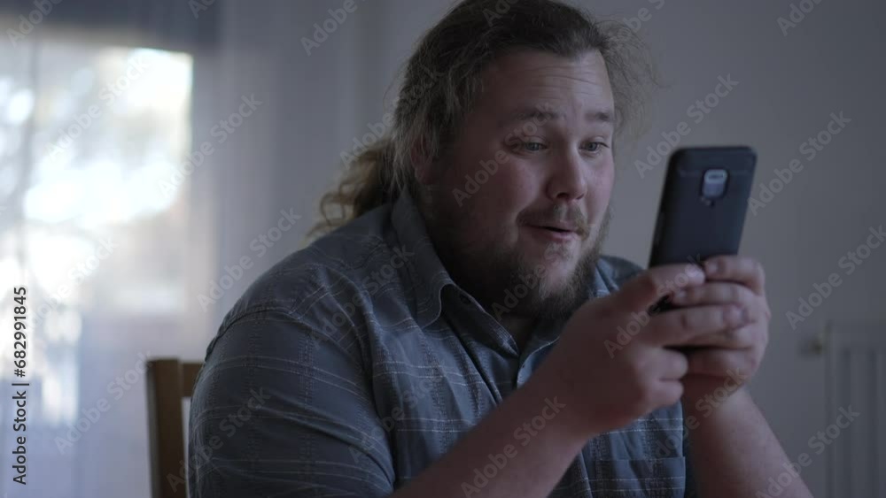 One excited guy celebrates success holding phone. Portrait of a fat man cheering for achievement. Happy winner concept One excited guy celebrates success holding phone. Portrait of a fat man cheering for achievement. Happy winner concept