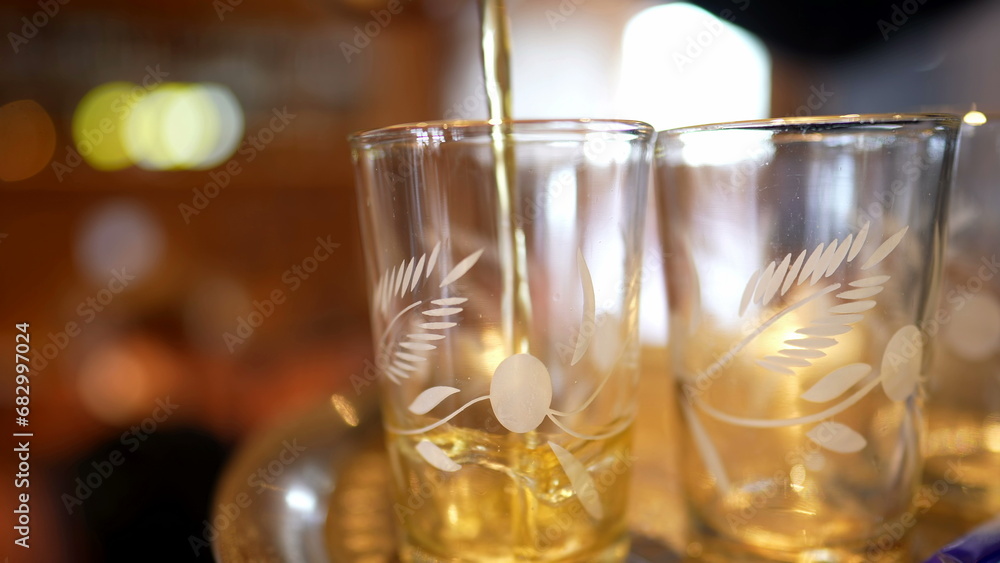 Serving Ritual - Pouring Fresh Tea into Glass Cup at Restaurant Serving Ritual - Pouring Fresh Tea into Glass Cup at Restaurant