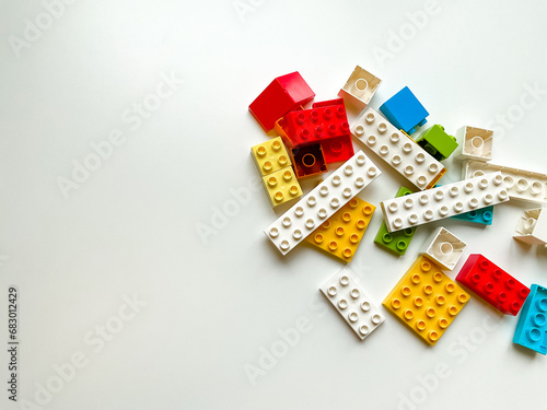 Top view of colorful plastic building blocks on white background with copy space photo