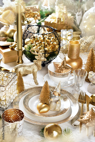 Christmas table setting with decors in white and gold colors photo