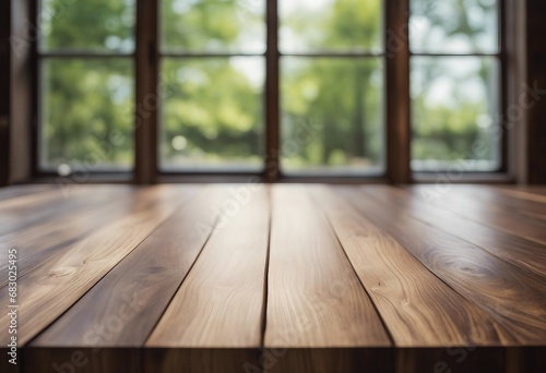 Empty wooden table in front of blurred in front of a large window with slightly blurred background
