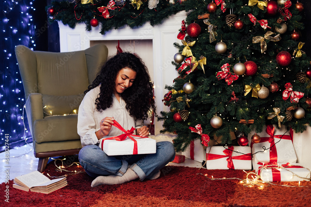Fototapeta premium brunette woman at christmas tree with gifts decoration for new year