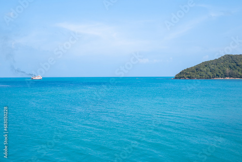 The blue surface of the sea with a ship sailing in the distance. Travel and tourism