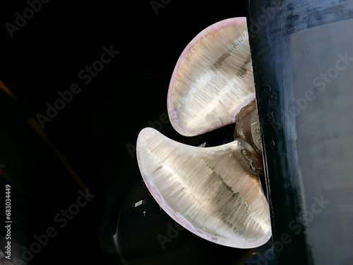 black gold. ship in dry-dock out of water. bronze polished propeller on black painted hull.