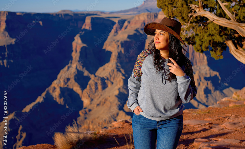 Naklejka premium Young woman enjoying the incredibly impressive view over the majestic Grand Canyon - travel photography