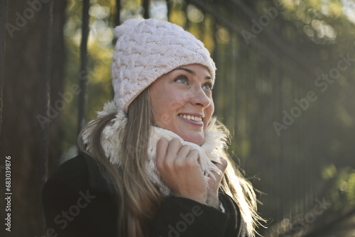 cheerful young woman with hat on the street