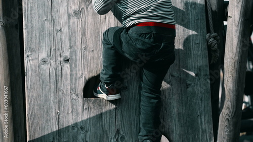 Child Engaging in Active Play, Climbing on Playground During Autumn at a Public Park